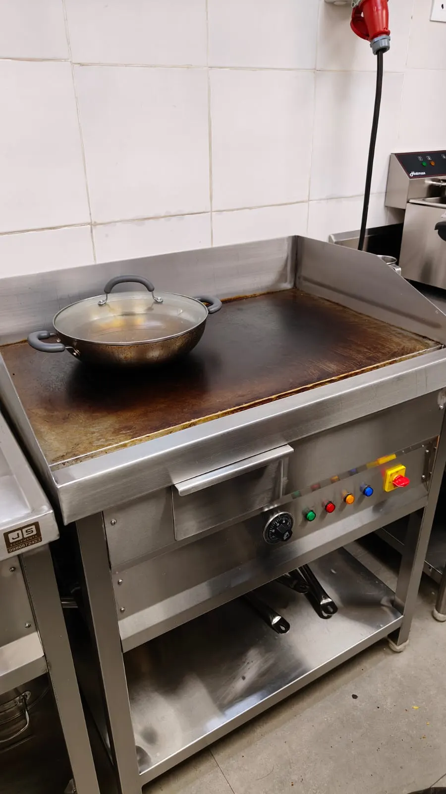 Commercial stainless steel hot plate griddle with a kadai on top