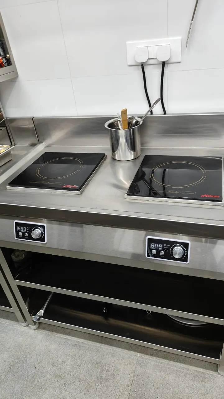 Side view of a commercial induction cooking station
