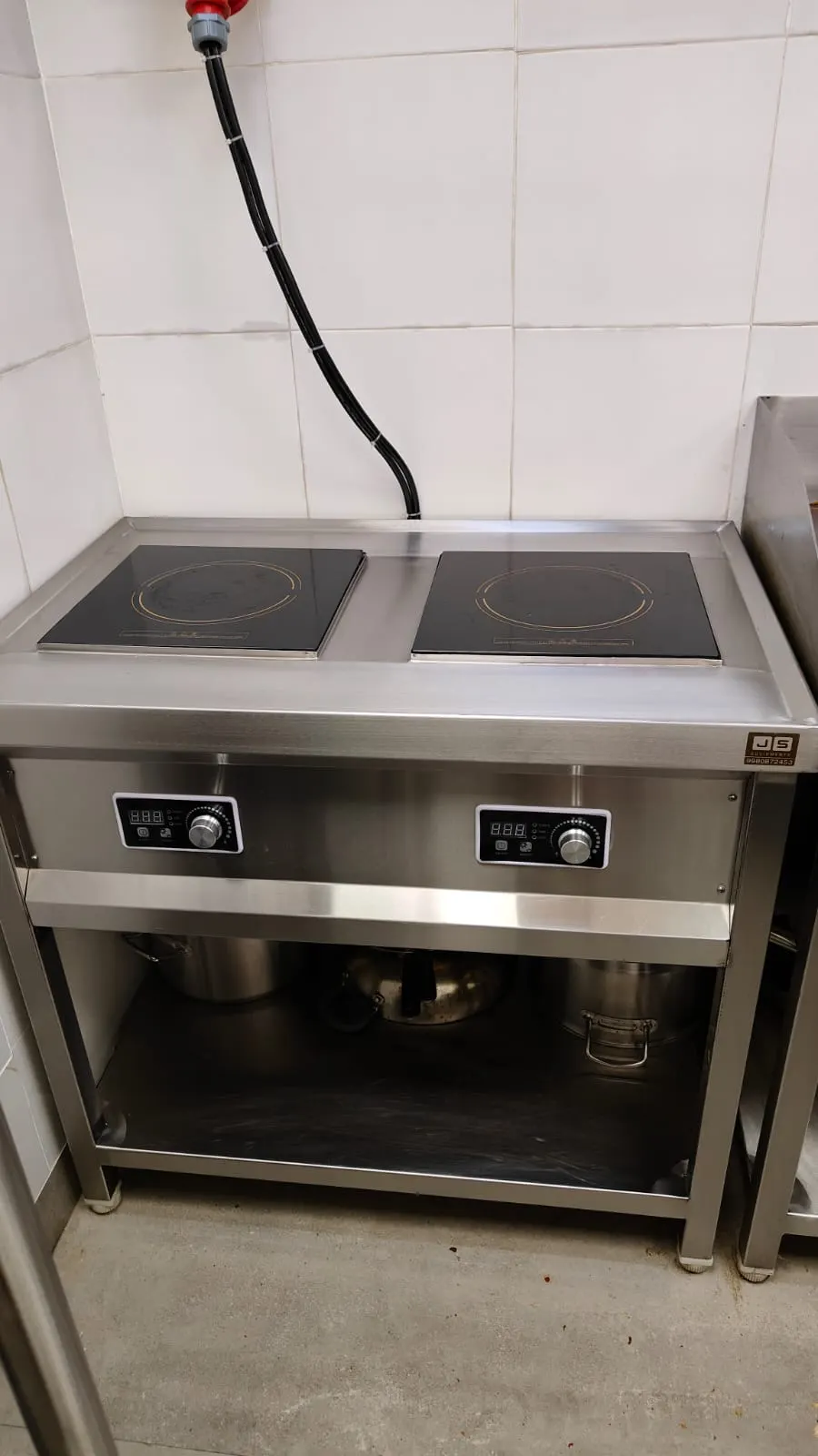 Two zone commercial induction cooktop on a stainless steel cabinet