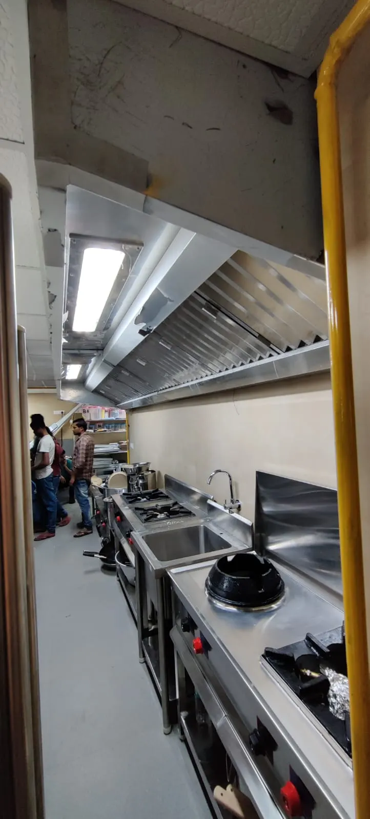 Long wall mounted exhaust hood over a cooking line