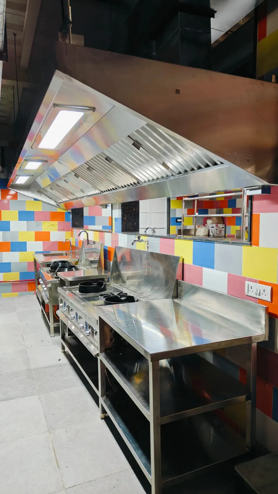Stainless steel work table with integrated sink under an exhaust hood